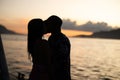 Silhouette of a loving couple kissing against a sunset sea background Royalty Free Stock Photo