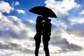 Silhouette of loving couple under umbrella