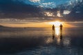 Silhouette of loving couple walking at sunrise on the salt lake of Bonneville Salt Flats, Wendover, Western Utah, USA, America.
