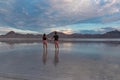 Silhouette of loving couple walking after sunrise on salt lake of Bonneville Salt Flats, Wendover, Western Utah, USA, America.
