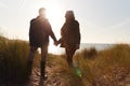 Silhouette Of Loving Senior Couple Holding Hands As They Walk Along Coast Path Against Flaring Sun Royalty Free Stock Photo