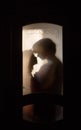 Silhouette Of A Loving Young Couple Hugging While Standing Outside The Door In The Room