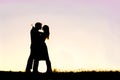 Silhouette of Loving Young Couple Hugging at Sunset Outside