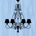 Silhouette of luxury chandelier on a scratched blue wallpaper