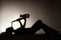 Silhouette of lying woman playing saxophone