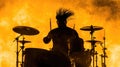 Silhouette of a male drummer performing against fiery backdrop Royalty Free Stock Photo
