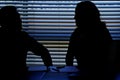 Silhouette of male and female coworkers flirting in office