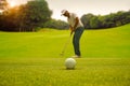 Silhouette male golfer putting golf ball on the green golf, lens flare on sun set evening time Royalty Free Stock Photo