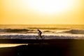 Silhouette of a male mountainbiker at sunset at the sea with wave for surfers in background - scenic place for sport adventure