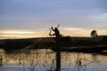 Silhouette Of A Malian Fisherman Hauling His Net Into His Boat On The Niger River At Sunset