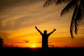 Silhouette of a man with arms outstretched towards the sky during sunset. Successful man Royalty Free Stock Photo