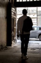 Silhouette of a man with a backpack going outside through an arch, selective focus. Concept: a person got lost, went to an unknown Royalty Free Stock Photo