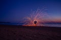 Silhouette of man on the beach making sparks with steel wool. Long exposure light painting photography. Light shapes on the beach Royalty Free Stock Photo
