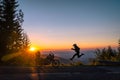 Silhouette of man biker and adventure motorcycle on the road with sunset light background. leap with joy. Top of mountains, Royalty Free Stock Photo