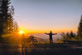 Silhouette of man biker and adventure motorcycle on the road with sunset light. Hands up. enjoy momment. Top of mountains, tourism Royalty Free Stock Photo