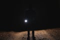 Silhouette of man with bright flashlight in forest Royalty Free Stock Photo