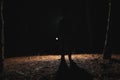 Silhouette of man with bright flashlight in forest Royalty Free Stock Photo