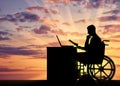 Silhouette of a man a businessman disabled in a wheelchair sitting at a table