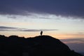 silhouette of a man in a cap sitting on a mountain watching the sunset. Royalty Free Stock Photo