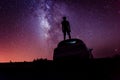 Silhouette of a man on a car against the Milky Way galaxy. Night sky. Astrophotography. Inspirational vibe. Infinite universe. Royalty Free Stock Photo