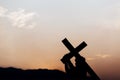 Silhouette of a man carrying a cross at sunset. concept of religion