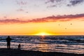 Silhouette of a man and child playing at the beach with beautiful sunset over sea Royalty Free Stock Photo