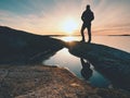 Silhouette man on cliff above sea. Tourist stand alone on rock and watch sea horizon Royalty Free Stock Photo