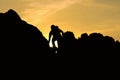 Silhouette of man climbing on rock mountain at sunset Royalty Free Stock Photo