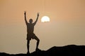 Silhouette of man is climbing to peak of hill