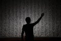 Silhouette of a man in a concert hall. Theatre teacher. The man raised his hand up. The beginning of the repitition in the theater Royalty Free Stock Photo