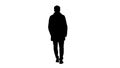 Silhouette Man with dark beard in light trench coat walks. Royalty Free Stock Photo