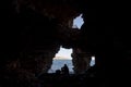 Silhouette of a man diving into water, view from a cave