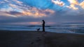Silhouette of man and dog at the beach at sunset Royalty Free Stock Photo