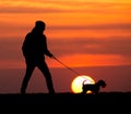 Silhouette of man with dog at sunset Royalty Free Stock Photo