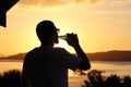 Silhouette of a man drinking beer at sunset Royalty Free Stock Photo
