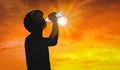 Silhouette Man Is Drinking Water Bottle On Hot Weather Background With Summer Season. High Temperature And Heat Wave Concept