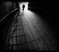 Silhouette of man entering a dark tunnel in black and white Royalty Free Stock Photo