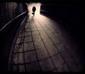 Silhouette of man entering a dark tunnel in bronze monochrome Royalty Free Stock Photo