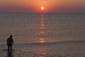 Silhouette of a man enters the sea