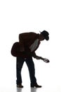 Silhouette of man in fedora hat playing guitar, performing isolated on white background. Black and white image. Royalty Free Stock Photo