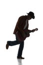 Silhouette of man in fedora hat playing guitar, performing isolated on white background. Black and white image. Royalty Free Stock Photo