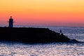 The silhouette of a man fishing on a rocky beach at sunset. Space for text.. motivational image