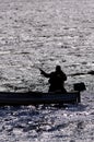 Silhouette of a man fishing from a small boat