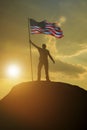 Silhouette of a man with the flag of the United States of America on top of a mountain. Royalty Free Stock Photo