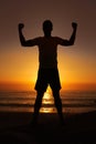 Silhouette, man and flex with sunset for winner, health and wellness on beach with sunrise and zen. Person, shadow and