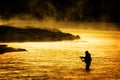 Silhouette of Man Flyfishing Fishing in River Golden Sunlight early morning fisherman yellowstone river Royalty Free Stock Photo