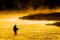 Silhouette of Man Flyfishing Fishing in River Golden Sunlight Royalty Free Stock Photo