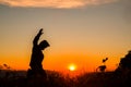 Silhouette of a man with hands raised in the sunset Royalty Free Stock Photo