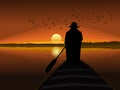 silhouette of a man in a hat rowing a small boat with the sun in the background Royalty Free Stock Photo