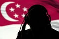 The silhouette of a man with headphones, listening secret agent, spy and intelligence officer, the Singapore flag, contour lightin Royalty Free Stock Photo